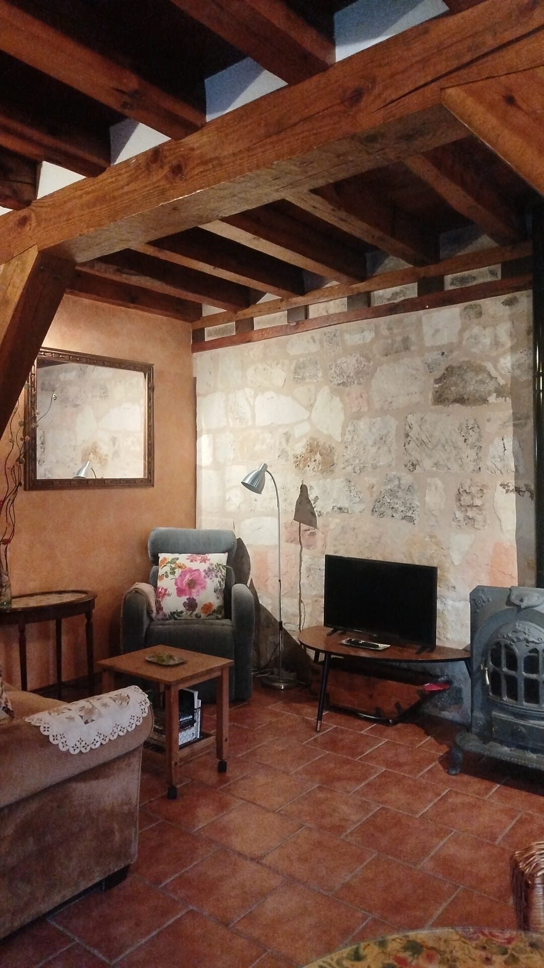 Salón con chimenea de leña, sofá y televisión — Mi Rinconcillo